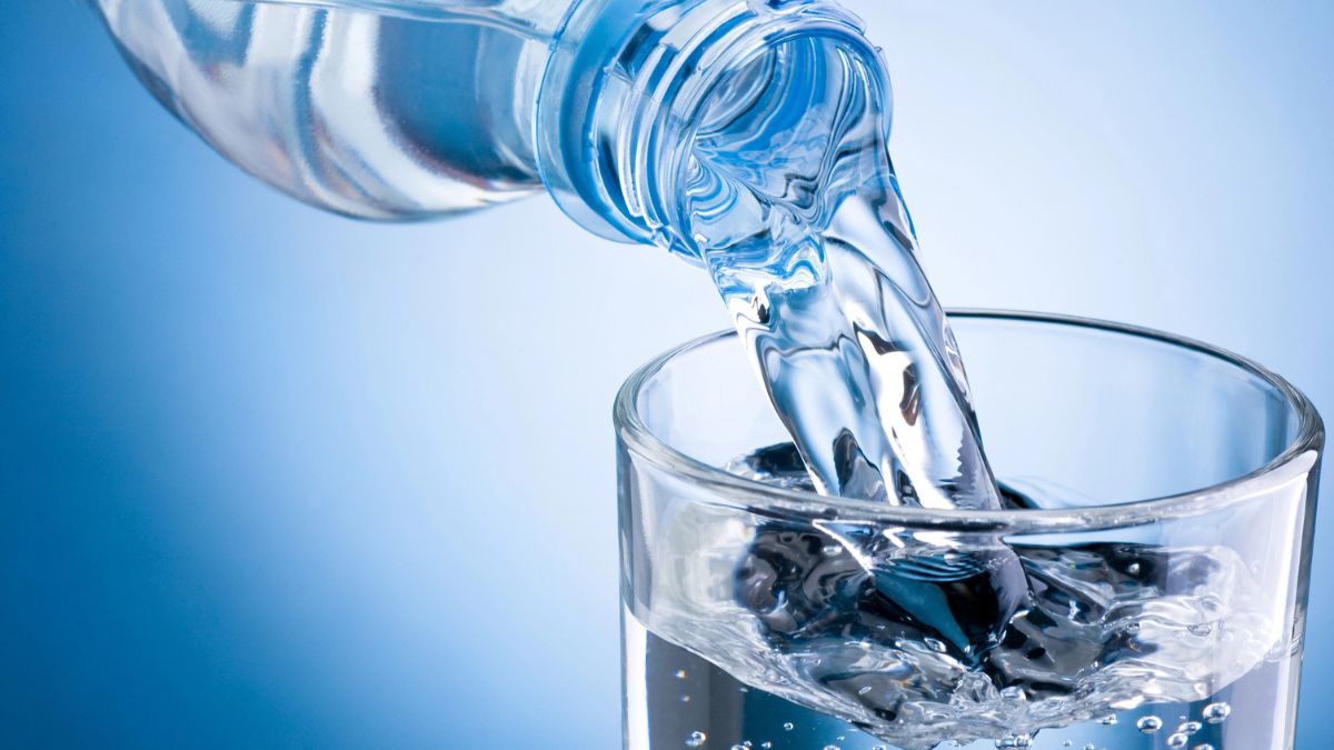 bottle of water pouring into glass