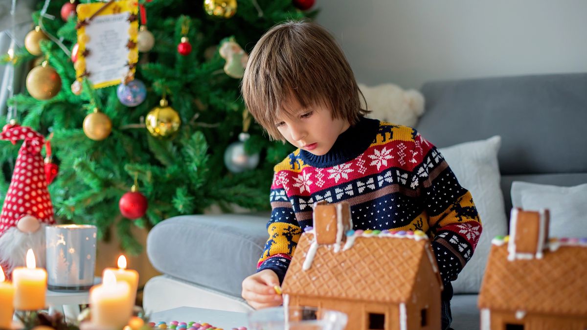 boy decorating gingerbread house