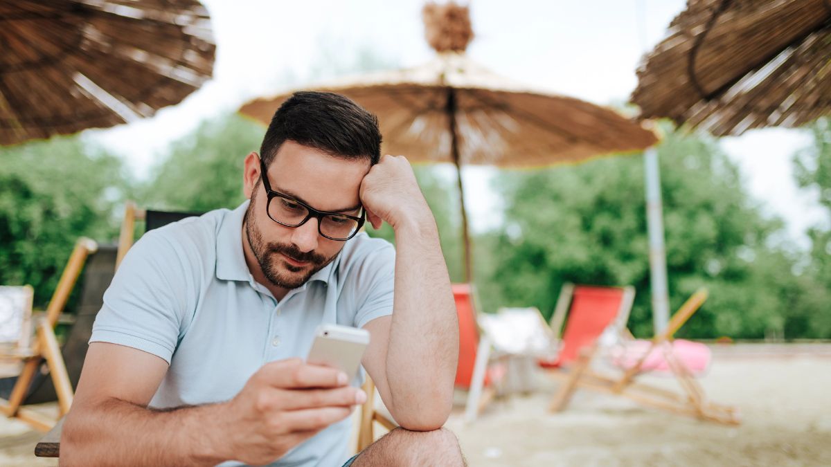 frustrated man on phone at beach