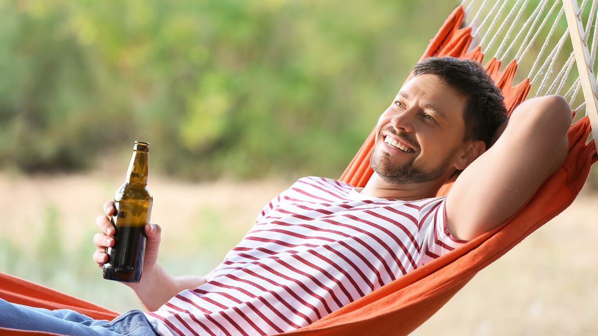 man on hammock with beer