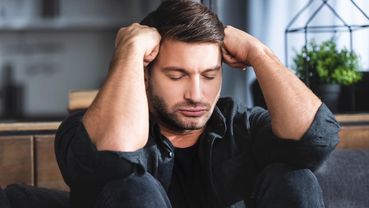 man sitting on the ground looking stressed