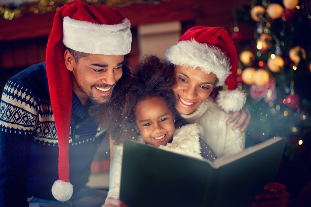 parent together reading their little daughter Christmas
