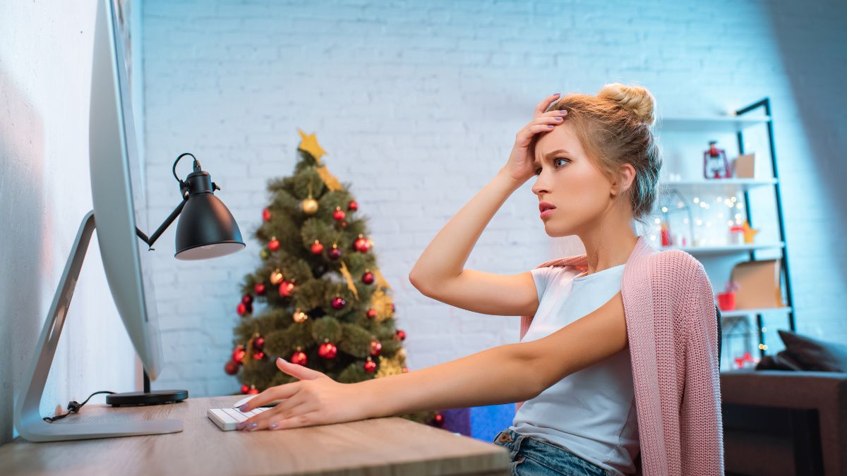 woman on computer with christmas tree stressed