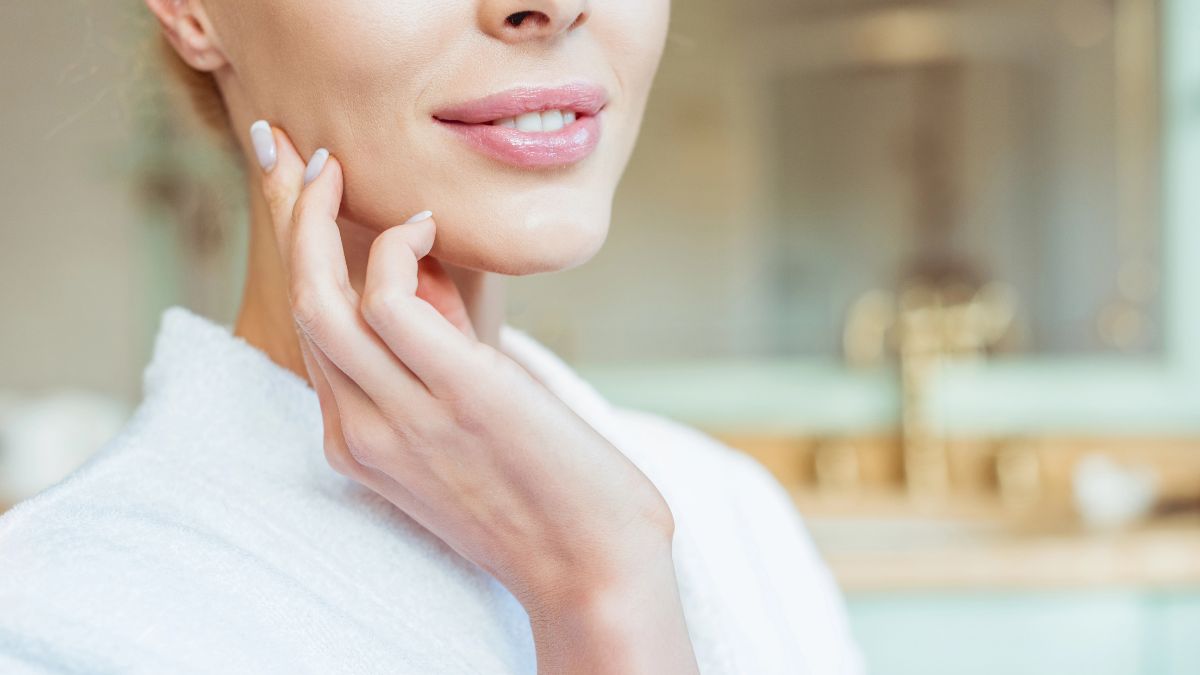 woman smiling with hand on face