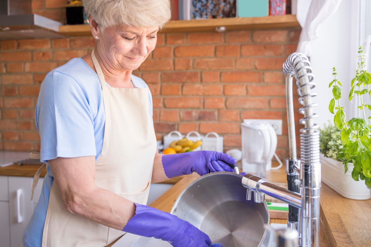 Older lady washing dishes