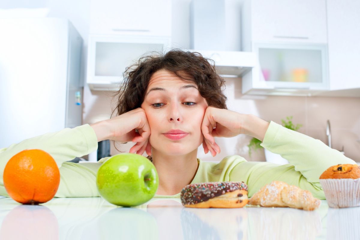 woman looking at fruit and baked goods deciding
