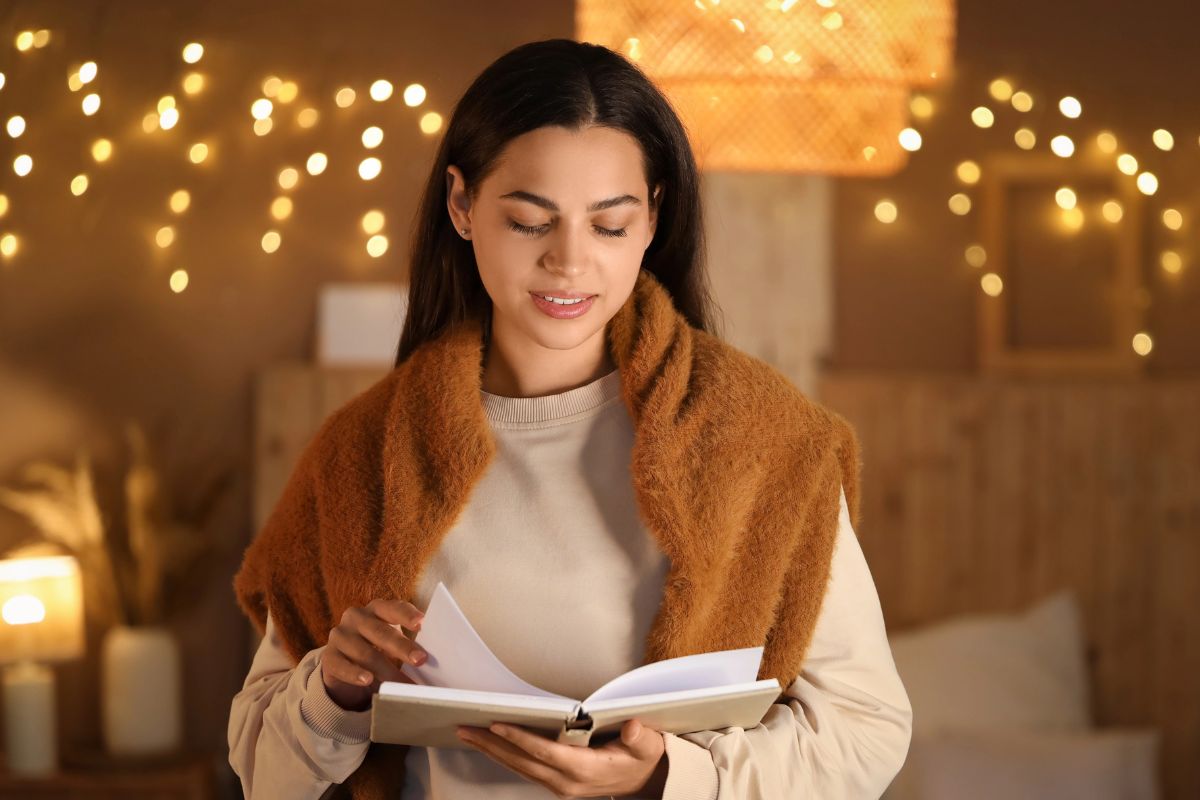 woman reading a book standing in her cozy room