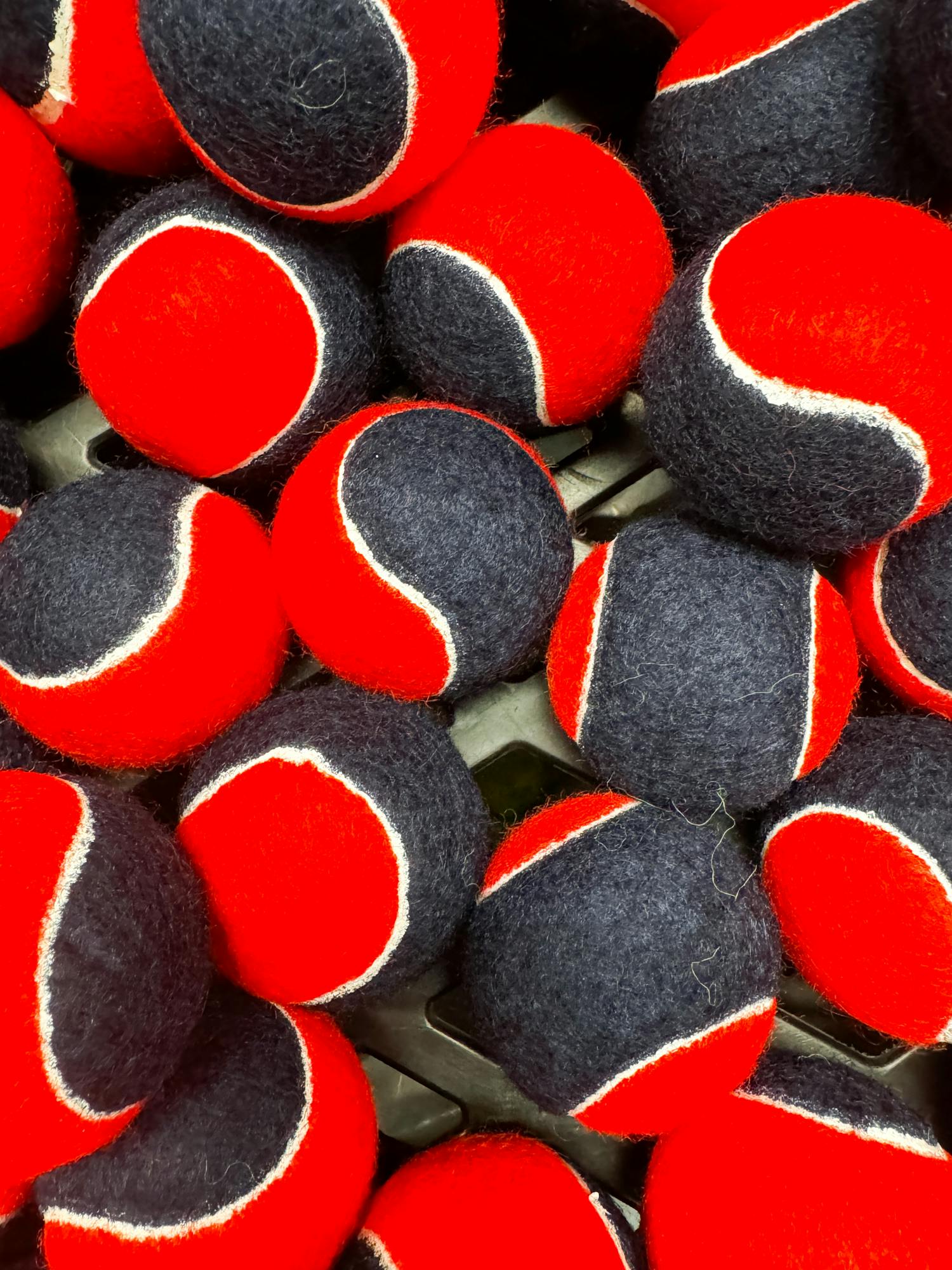 Vibrant red and blue tennis balls stacked in Box, England, ideal for sports enthusiasts.