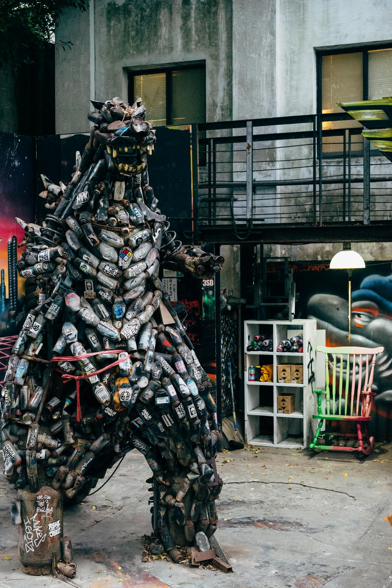 Unique scrap metal Godzilla sculpture in Taipei's urban art district, showcasing imagination and zero waste principles.