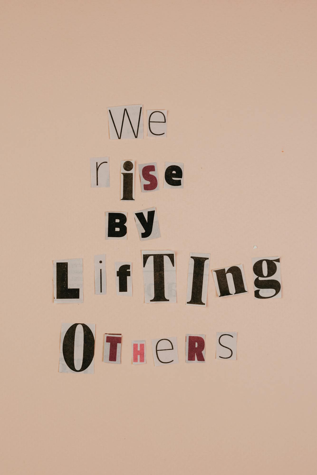 Motivational words on cutouts forming an uplifting message on a beige background.