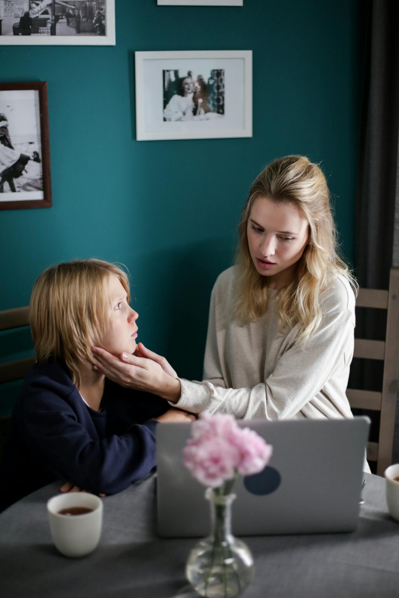 Mother comforting her child while using a laptop, illustrating online safety conversations about groups like 764.